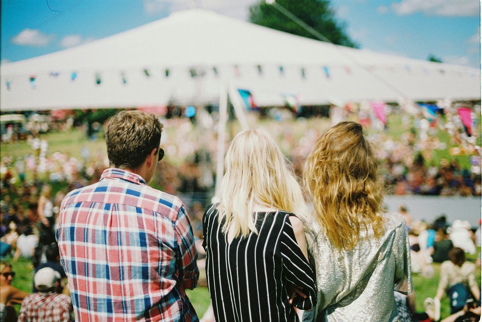 People infont of a tent at a festival.